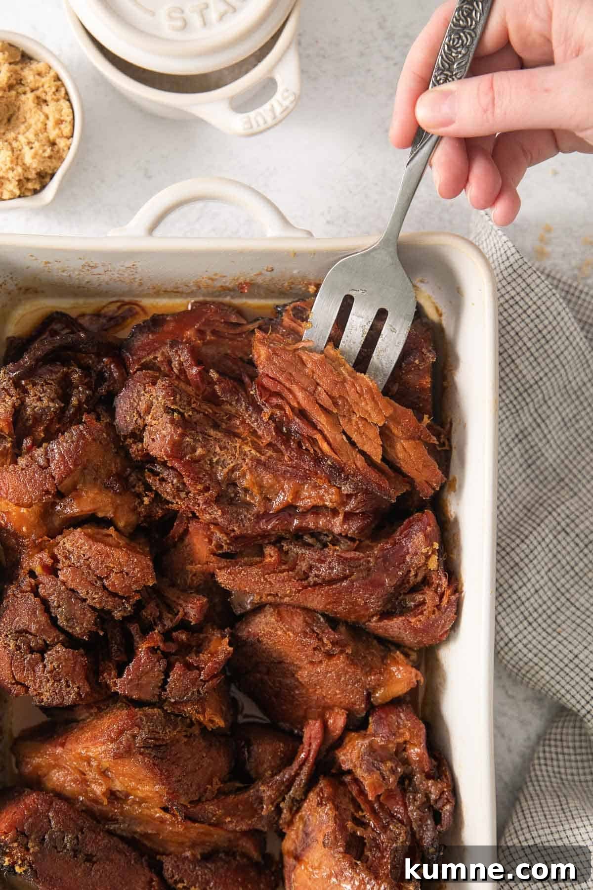 Gluten-Free Baked Ham Recipe for Flavorful Holiday Meals 5 Gluten-free sweet baked ham on a baking dish with a fork picking up a piece