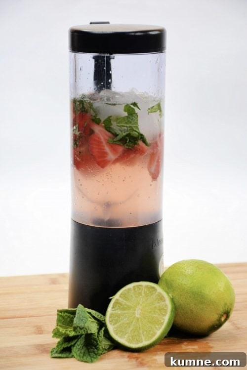 Refreshing Strawberry Mojito Recipe: How to Make the Classic Cocktail 3 strawberries, rum, mint, and ice in a clear blender with a black top.