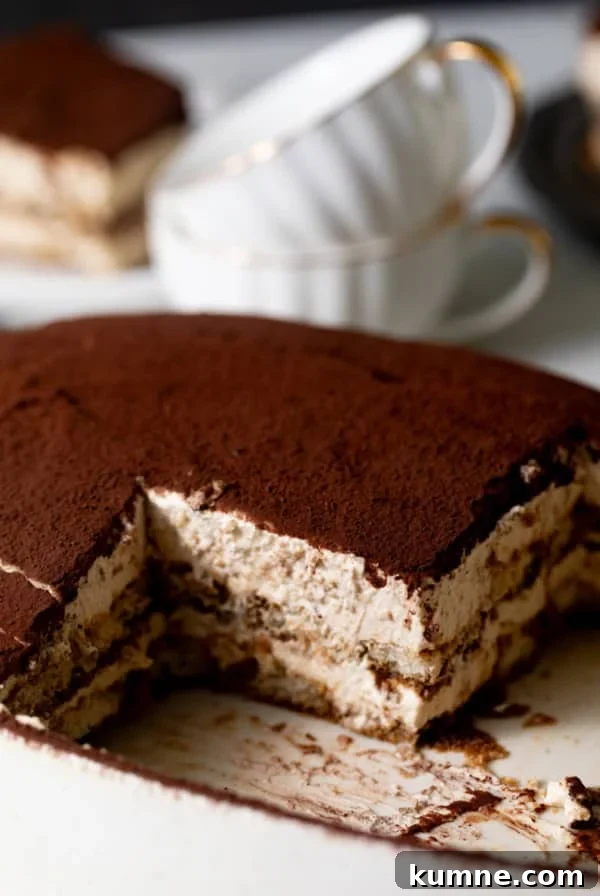 Homemade Banana Pudding Recipe: Classic from Scratch 13 tiramisu in an oval dish with a piece cut out so that you can see the layered center.