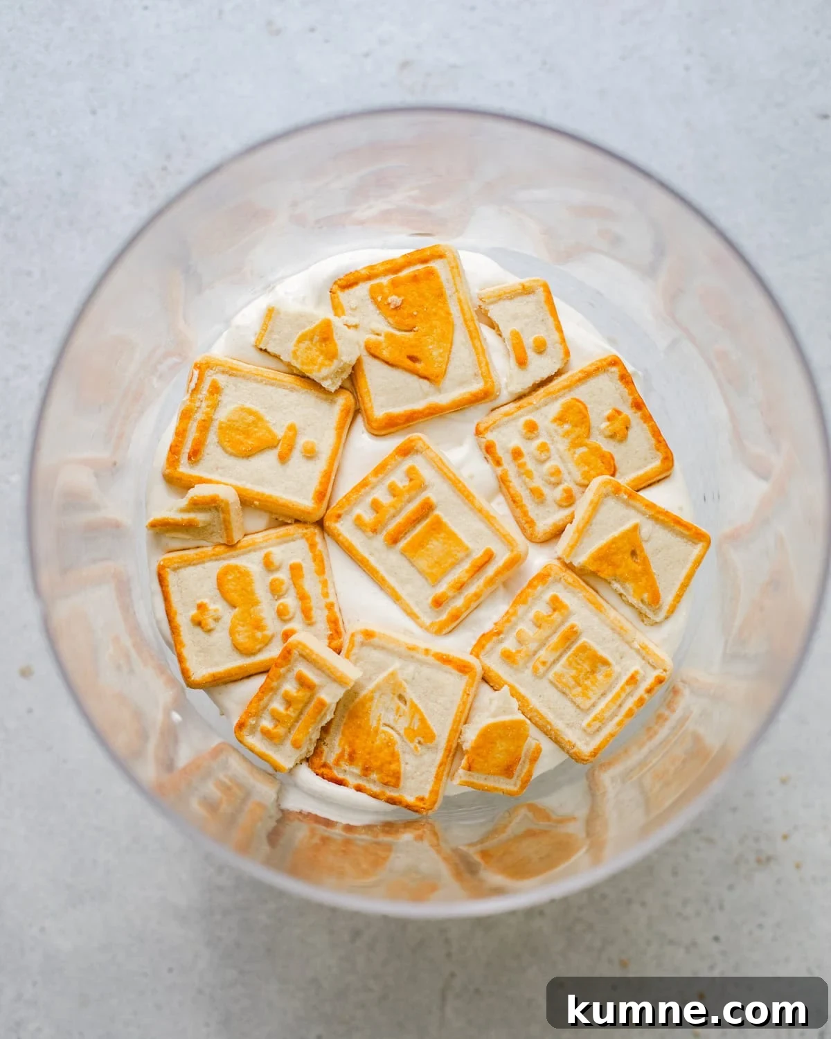 Homemade Banana Pudding Recipe: Classic from Scratch 8 overhead photo of whipped cream and chessman cookies in a trifle bowl.