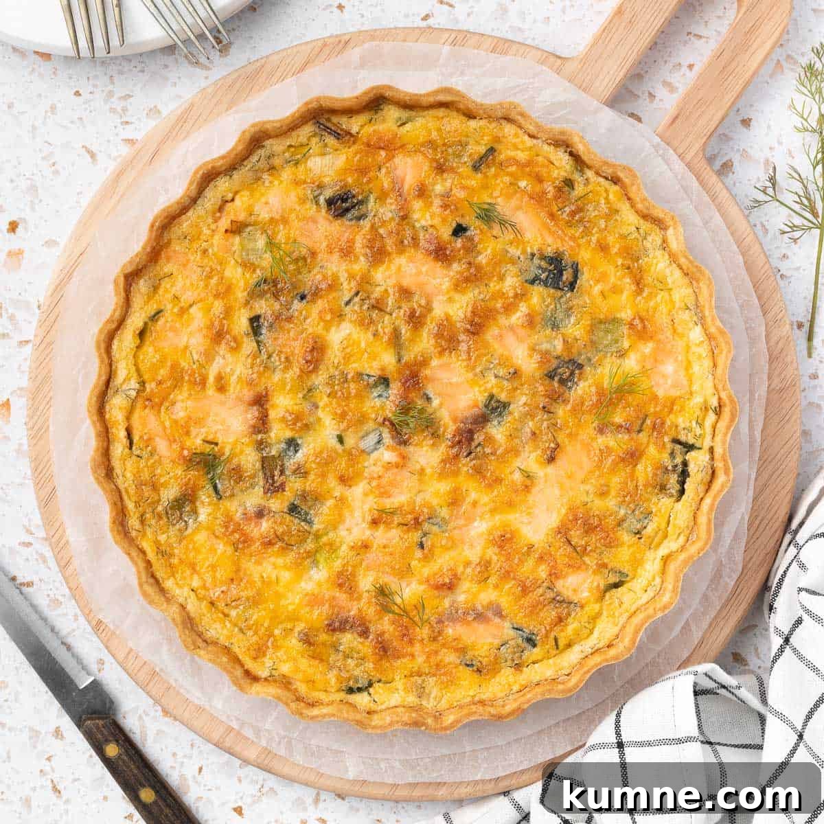 Smoked Salmon and Dill Quiche Recipe for Brunch 2 Salmon Quiche seen from above over a round wooden board and white baking paper sheets.