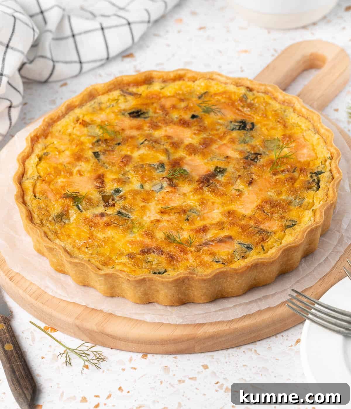 Smoked Salmon and Dill Quiche Recipe for Brunch 8 Baked quiche on a round wooden serving board.