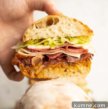 close up shot of hand holding sandwich showing filling