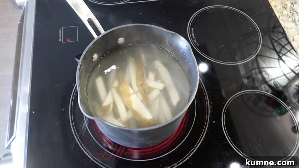 Potato sticks in a pot of hot water