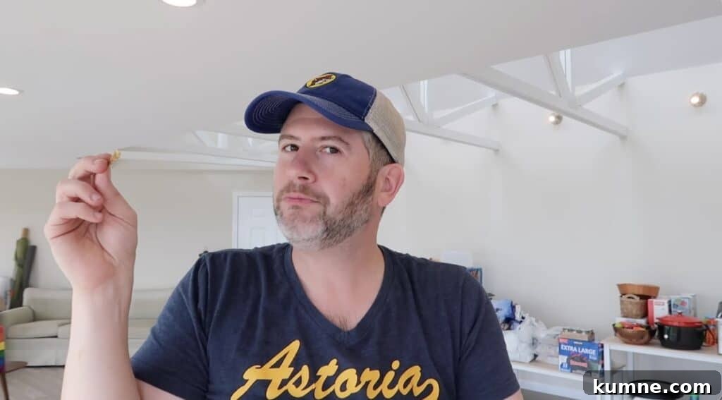 Man holding French fry and looking at camera.