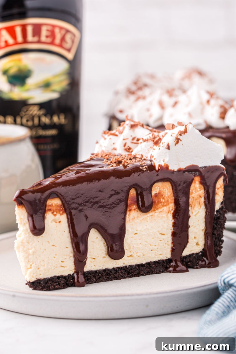 slice of baileys cheesecake on a plate next to a bottle of baileys irish cream
