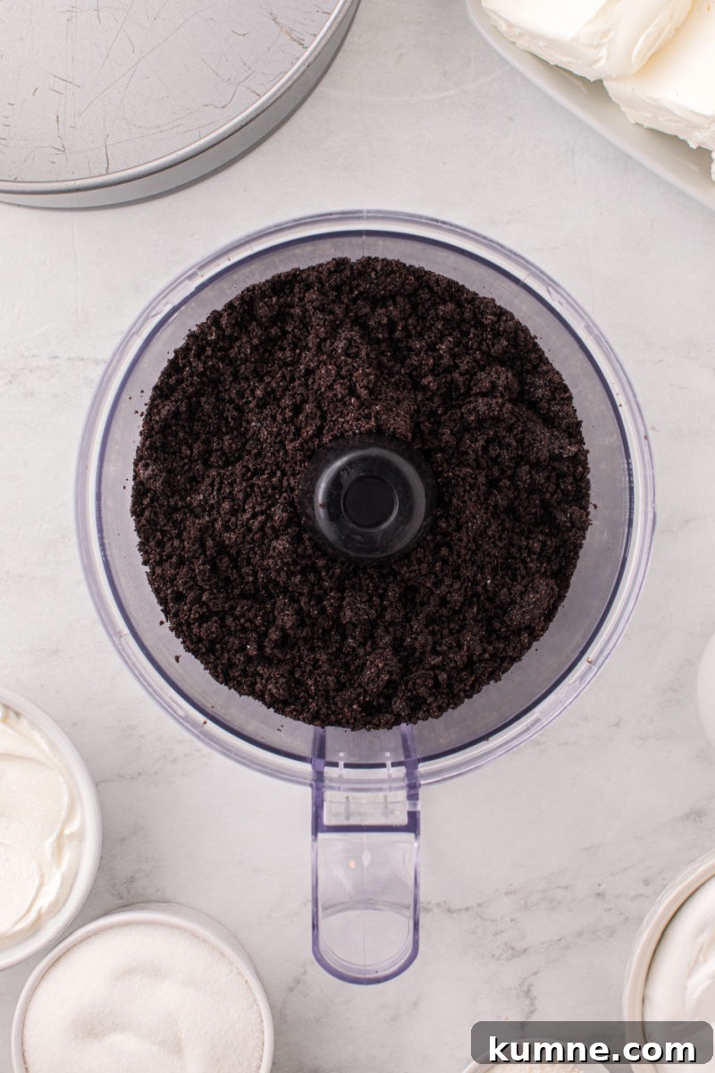oreo crumbs mixed with melted butter in a food processor bowl