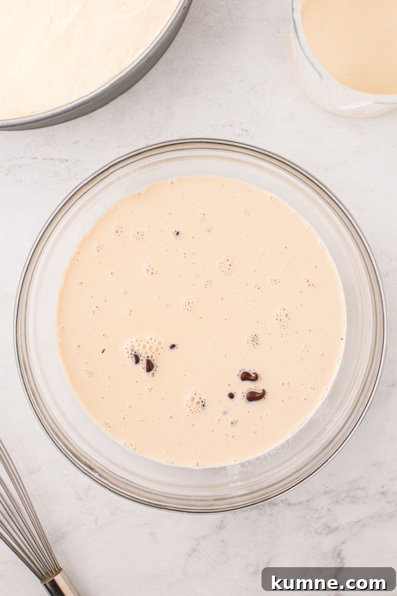 heated heavy cream and irish cream poured over chocolate chips in a bowl