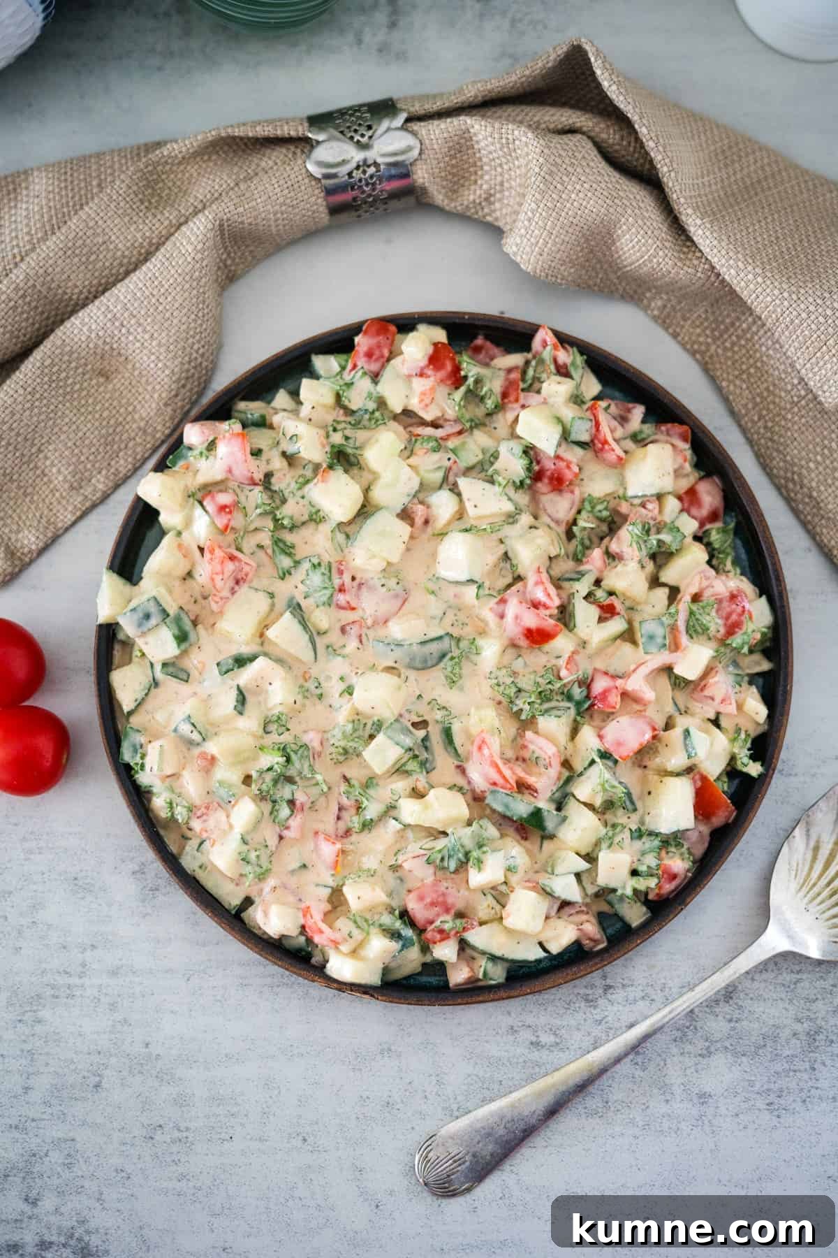 A fresh vegetable salad with diced tomatoes and cucumbers on a plate, ready to be served.