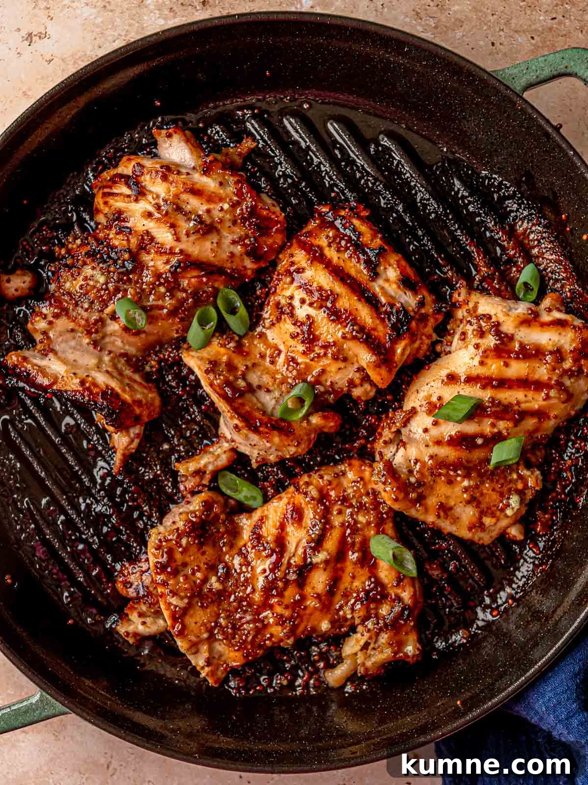 Honey Mustard Grilled Chicken Recipe for Juicy, Flavorful Results 2 Grilled chicken thighs with honey mustard glaze and grill marks in a cast iron pan.