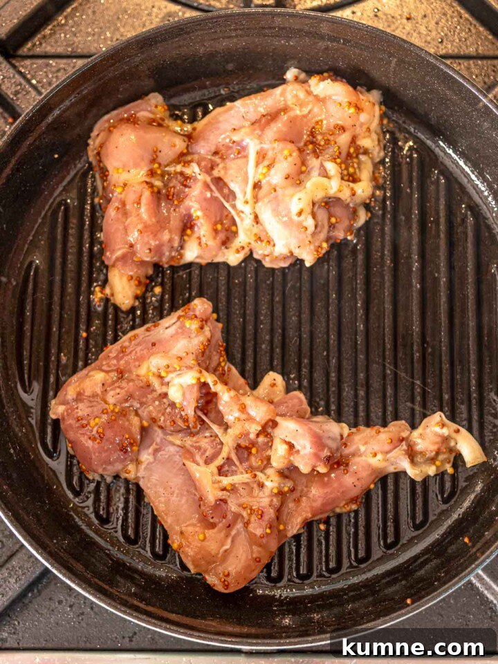 Honey Mustard Grilled Chicken Recipe for Juicy, Flavorful Results 6 Chicken thighs cooking on a stovetop grill pan with visible mustard marinade.