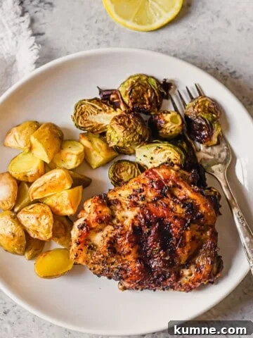 A plate filled with a lemon pepper seasoned chicken thigh and veggies.
