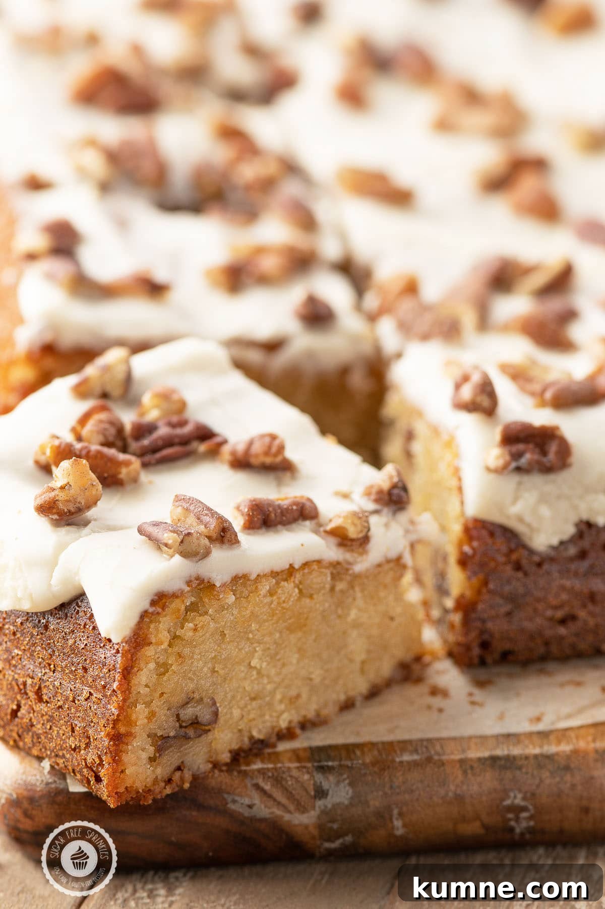 Low-Carb Maple Pecan Blondies — Chewy, Gooey Treats 4 A slice of low carb maple blondie cut from a full slab on a rustic wooden cutting board.