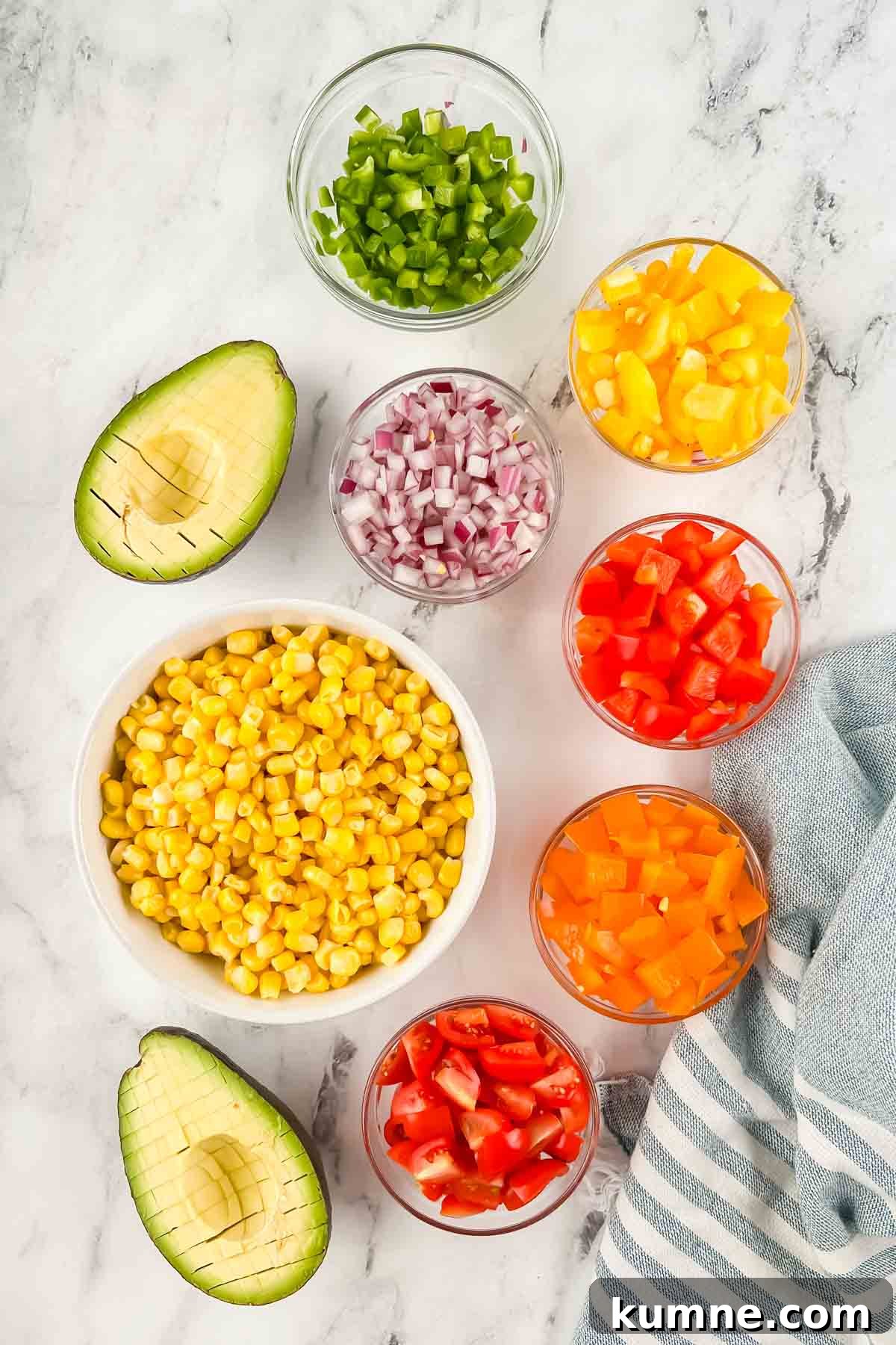 Festive Mexican-Style Fiesta Rice Recipe 5 Diced peppers, onion, tomato, corn, and avocado in individual bowls on white marble background