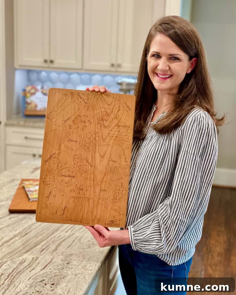 Halloween Guest Signature Board Ideas for Parties and Events 4 Maegan Brown holding her signature board while standing in her kitchen.