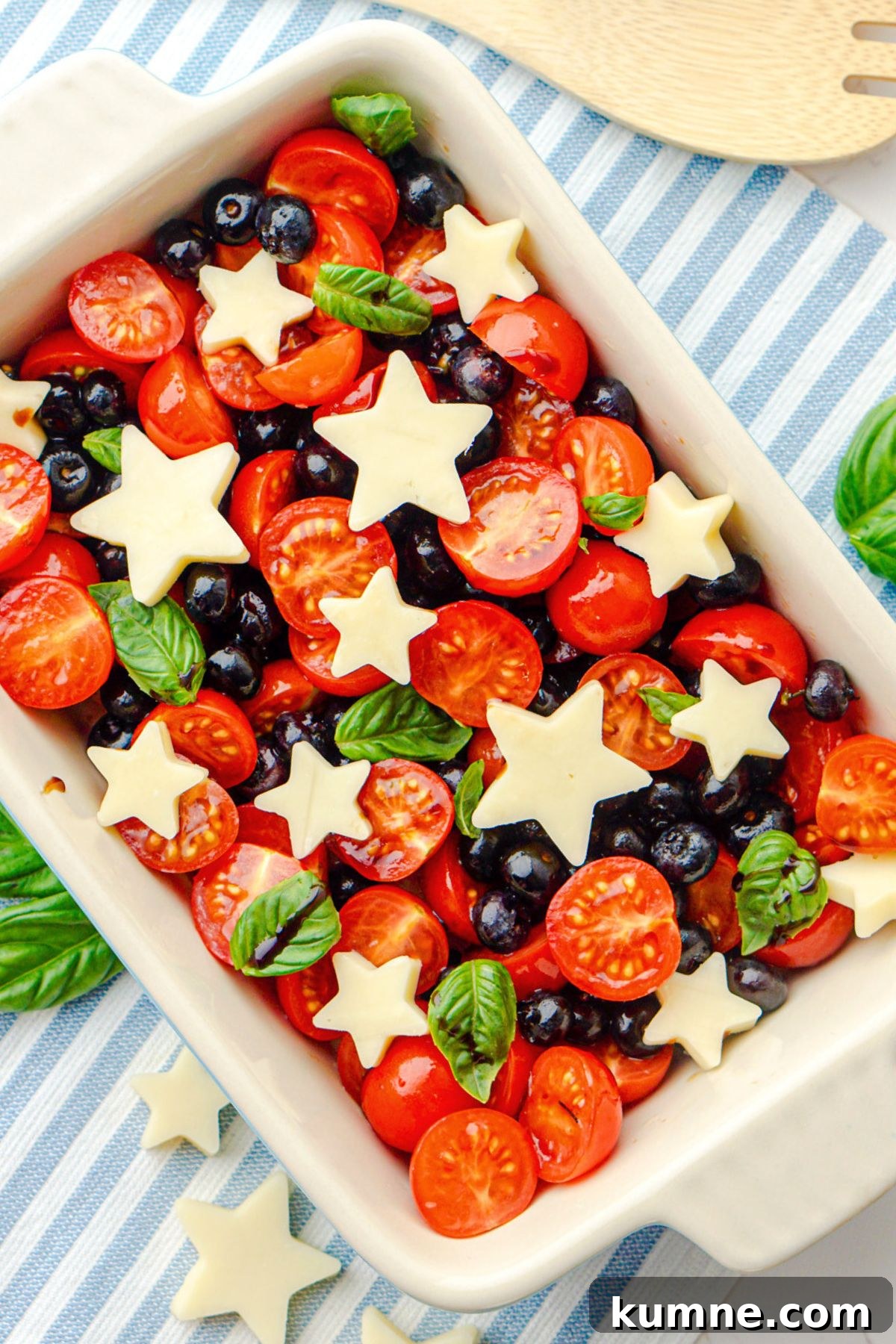 Berry Caprese Salad with Balsamic Glaze and Fresh Basil 2 Blueberries, tomatoes, and mozzarella cheese shaped into stars, in a rectangle baking dish.