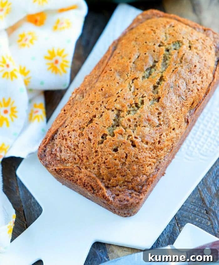 Grandma's moist zucchini bread A loaf of moist zucchini bread sits on a white cutting board, accompanied by a yellow floral napkin, reminiscent of a delightful zucchini bread recipe.