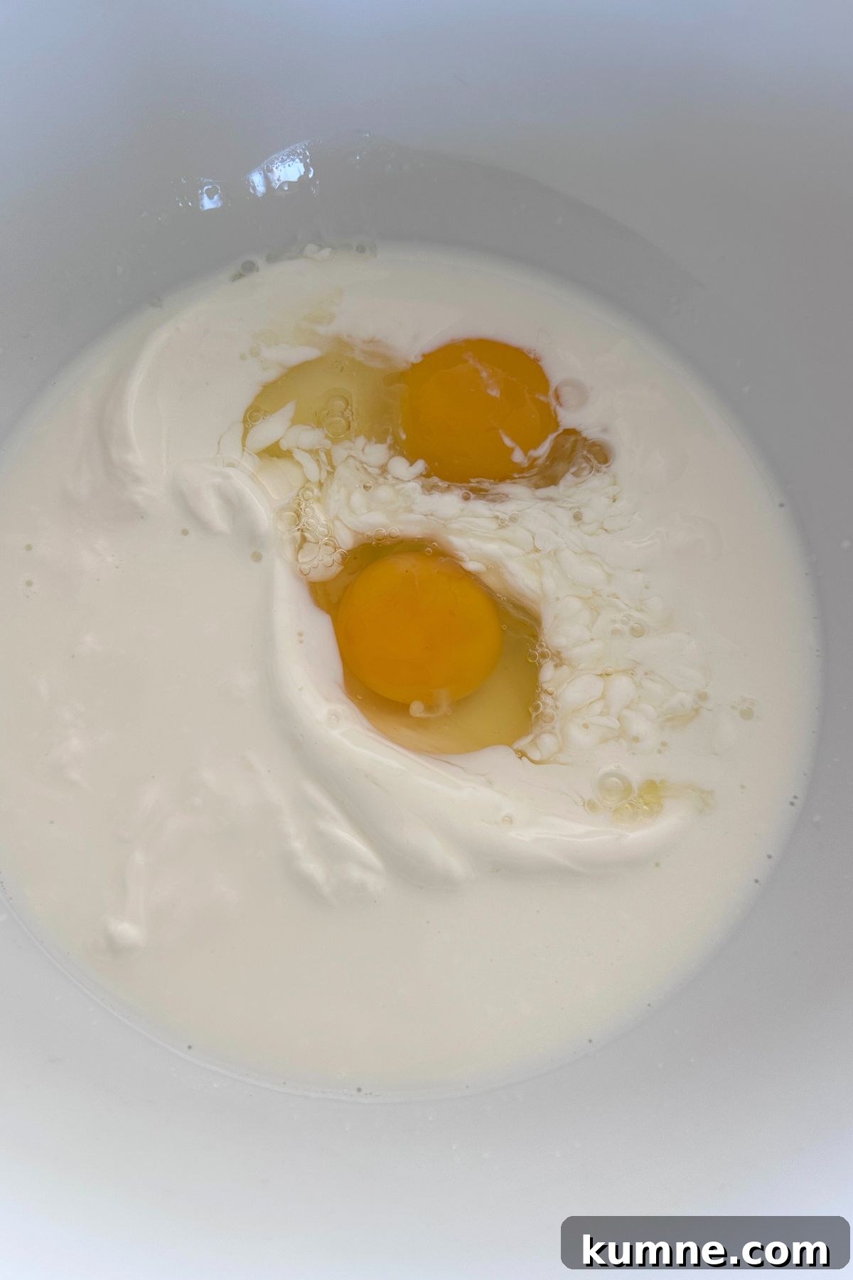 Creamy Baked Jalapeño Cheddar Corn Pudding Recipe from Scratch 5 Large mixing bowl, with yogurt, milk, and eggs ready to mix.