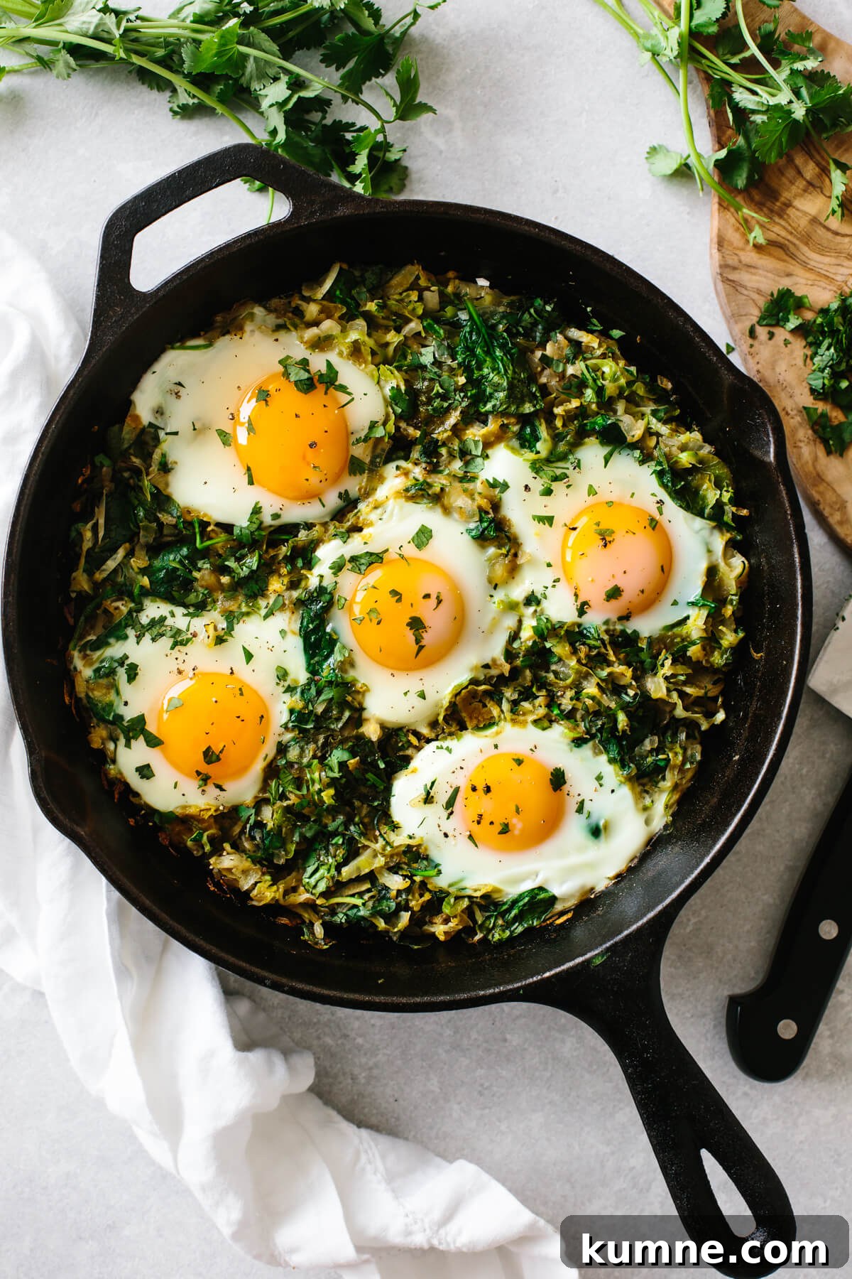 A cast iron pan filled with green shakshuka.