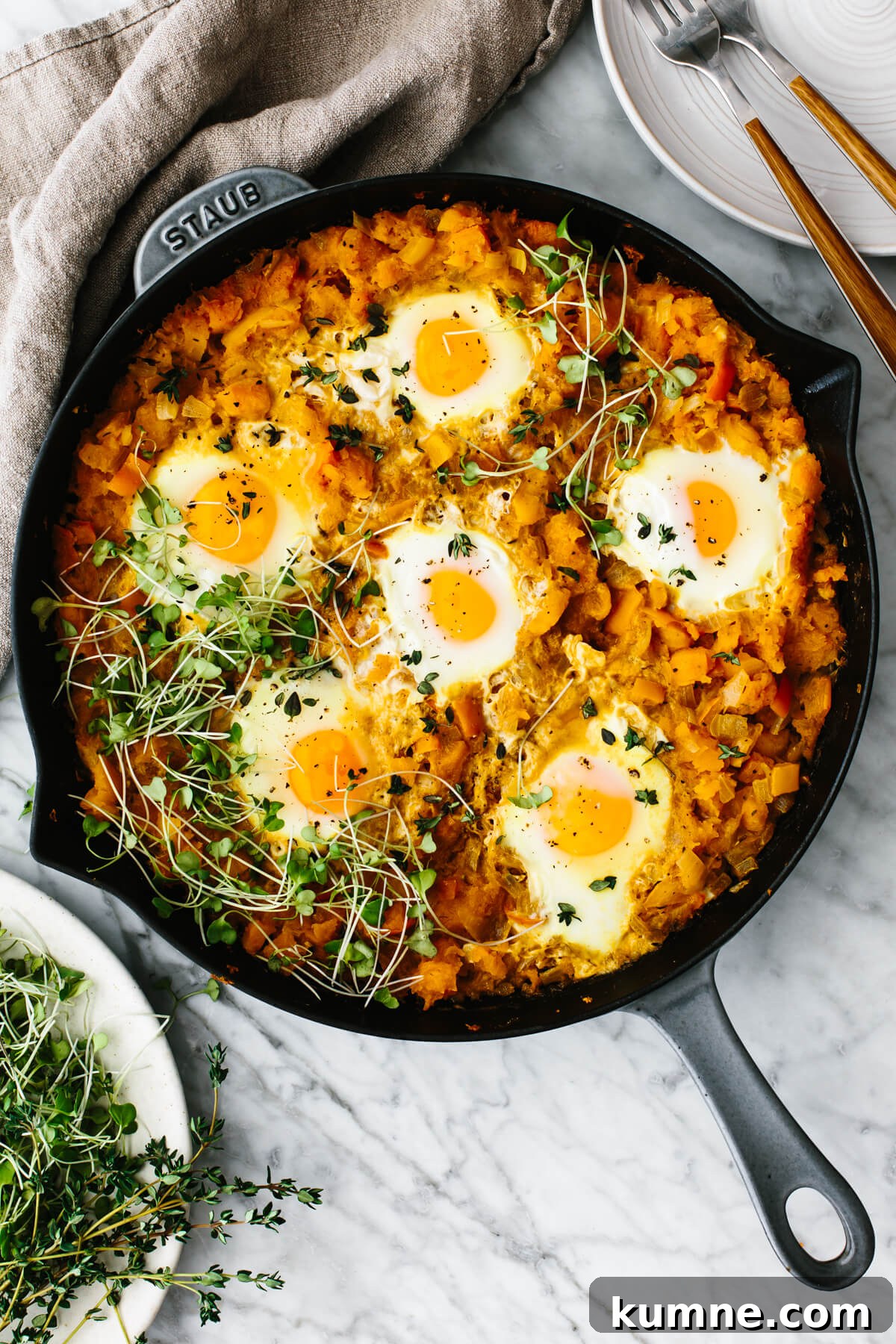 Orange shakshuka in a skillet on a table.