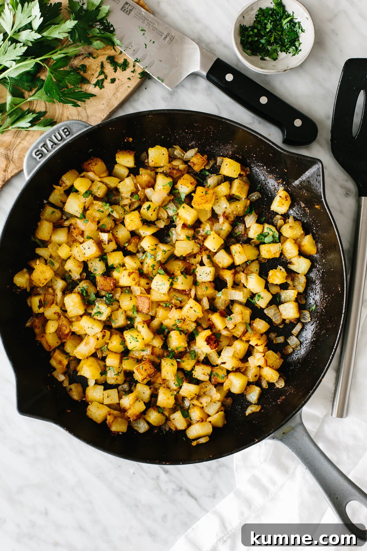 Breakfast potatoes in a skillet on a table.