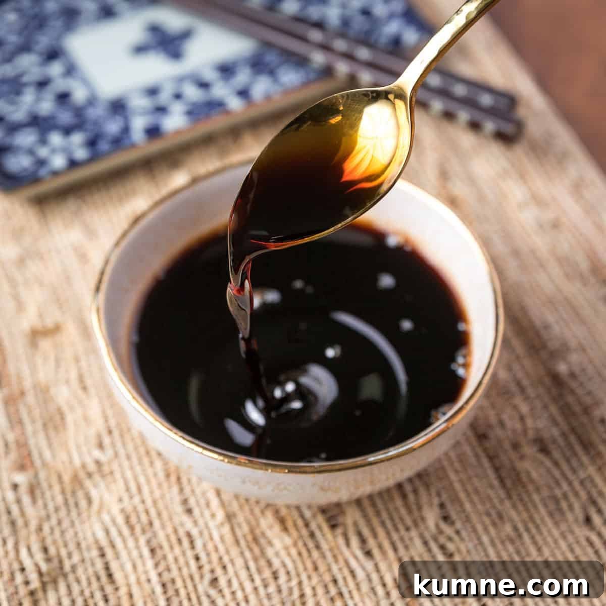 gold teaspoon pouring teriyaki sauce into a small bowl