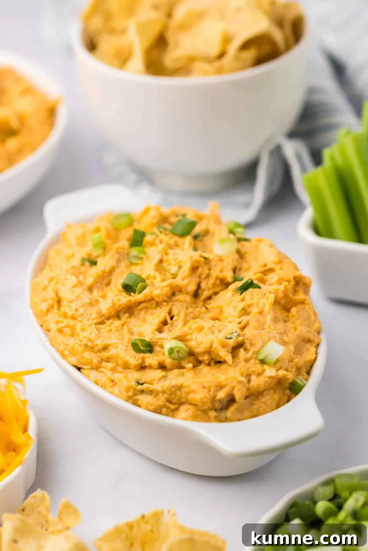 Slow Cooker Buffalo Chicken Dip Recipe for Game Day Snacks 2 An oval baking dish filled with a hot baked dip.