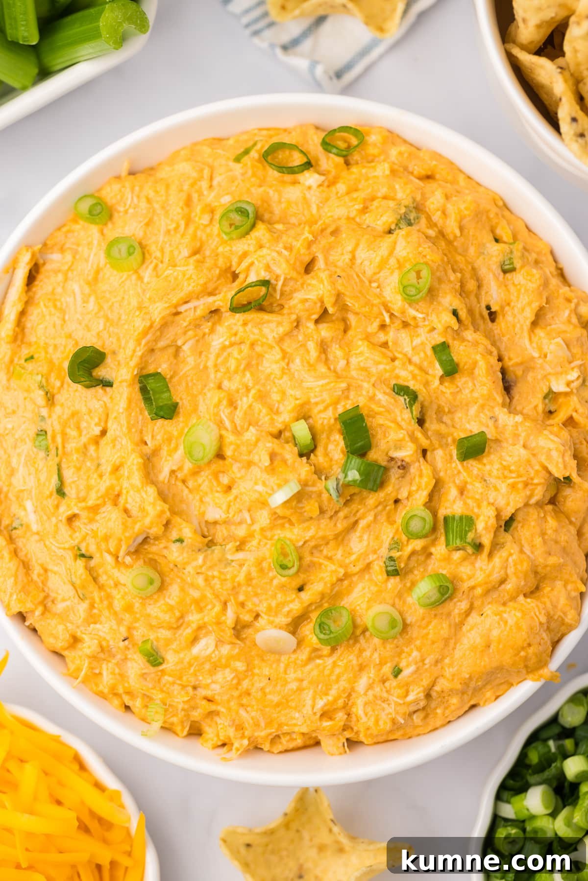 Slow Cooker Buffalo Chicken Dip Recipe for Game Day Snacks 12 A bowl of chicken dip garnished with chopped green onions.