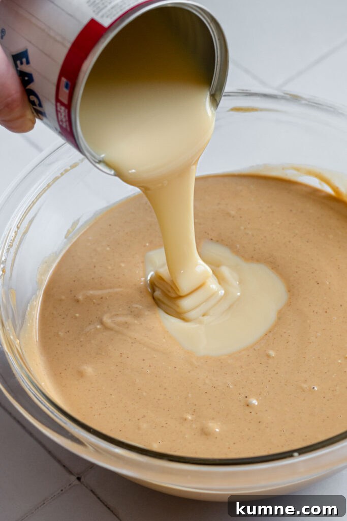 Peanut Butter Marshmallow Fluff Fudge (Fluffernutter) 7 Sweetened condensed milk pouring into the fudge.
