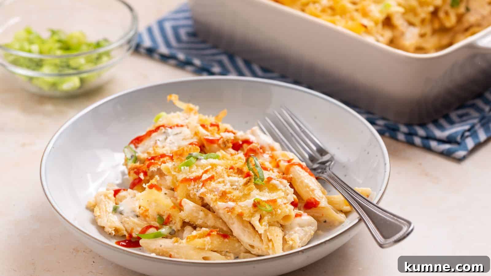 Serving of buffalo chicken pasta bake with casserole dish.