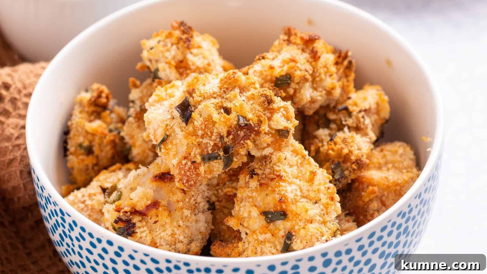 A bowl of golden brown popcorn chicken on a table.