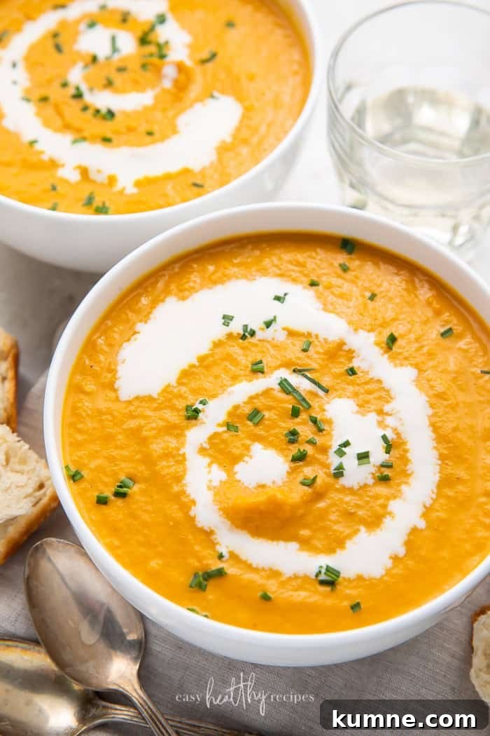 Creamy Pumpkin Bisque Recipe — Smooth Autumn Soup 2 Overhead shot of two bowls of pumpkin bisque garnished with cream and chives