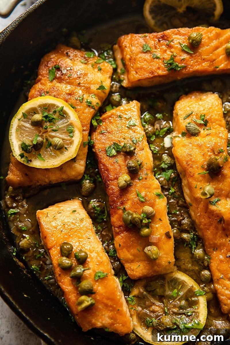 Lemon Caper Salmon Piccata Recipe with Garlic Butter Sauce 5 close up of salmon piccata in a cast iron pan