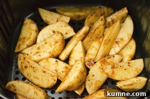 curried wedges in the air fryer ready to be cooked