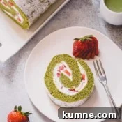 Matcha Swiss Roll Cake Recipe — Light, Fluffy Japanese Roll 10 A slice of strawberry matcha roll cake on a white serving plate.