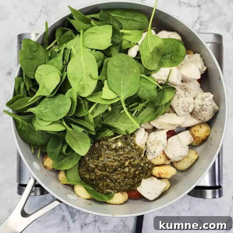 Return chicken and stir in pesto and spinach.