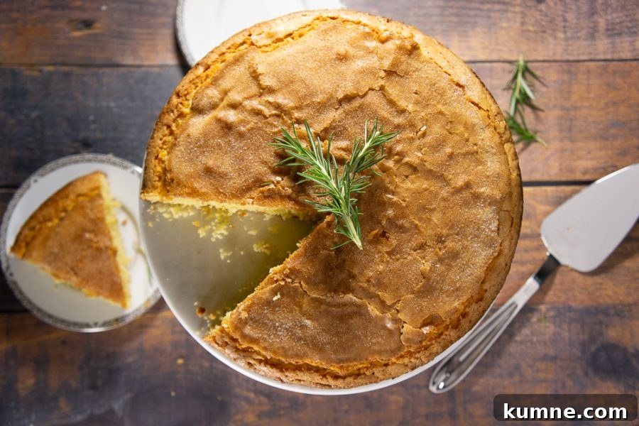 An olive oil cake with one slice cut out on a small plate