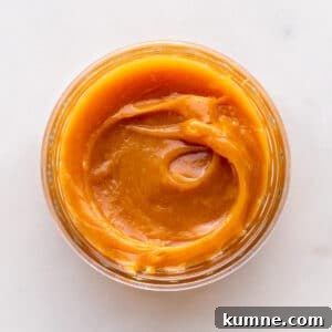 A jar of homemade milk jam viewed from the top to show the gooey, thick texture.