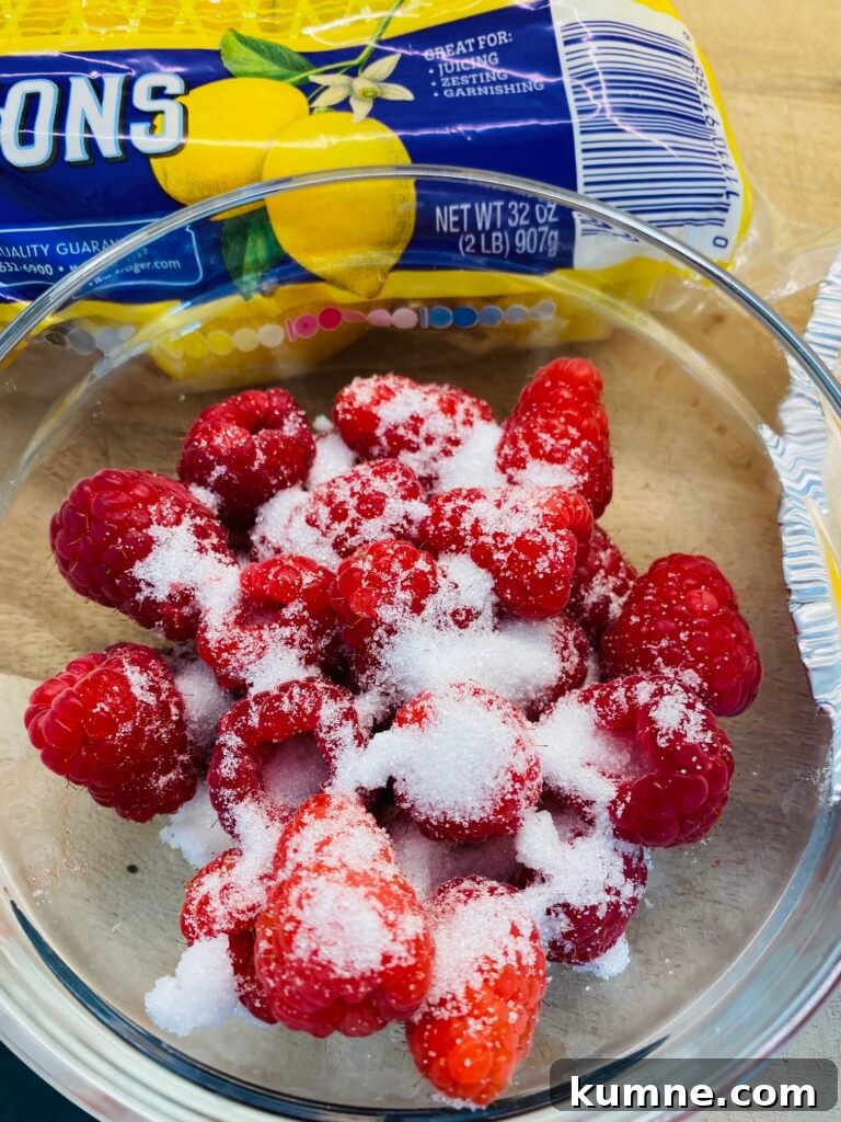 adding sugar to the raspberries