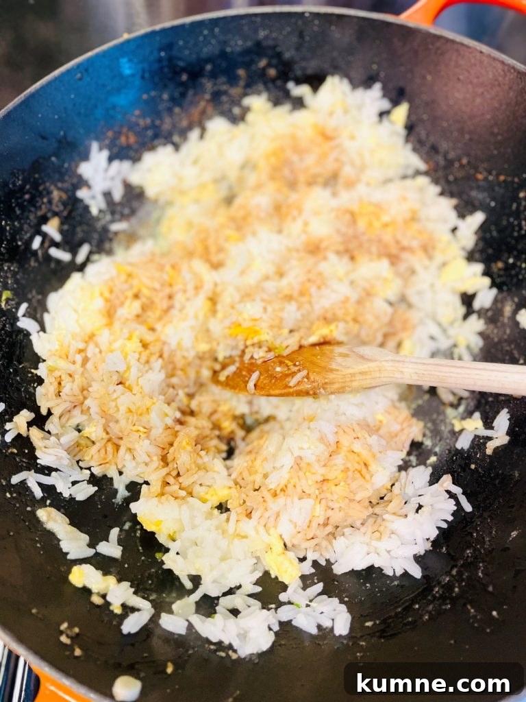 Chicken Fried Rice Recipe: Quick Homemade Takeout-Style Meal 7 Pan full of egg fried rice being mixed