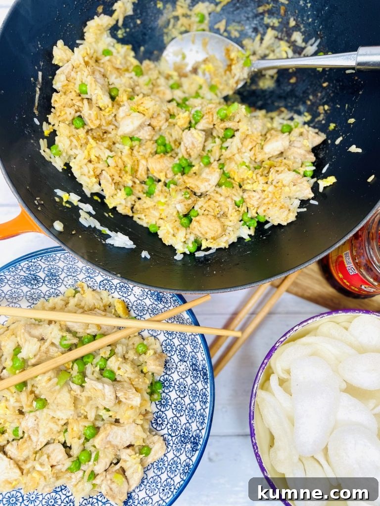 Chicken Fried Rice Recipe: Quick Homemade Takeout-Style Meal 2 Blue and white bowl of chicken fried rice with peas and chopsticks