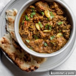 Pakistani Beef Curry (Stew) in a bowl on top of a plate with naan