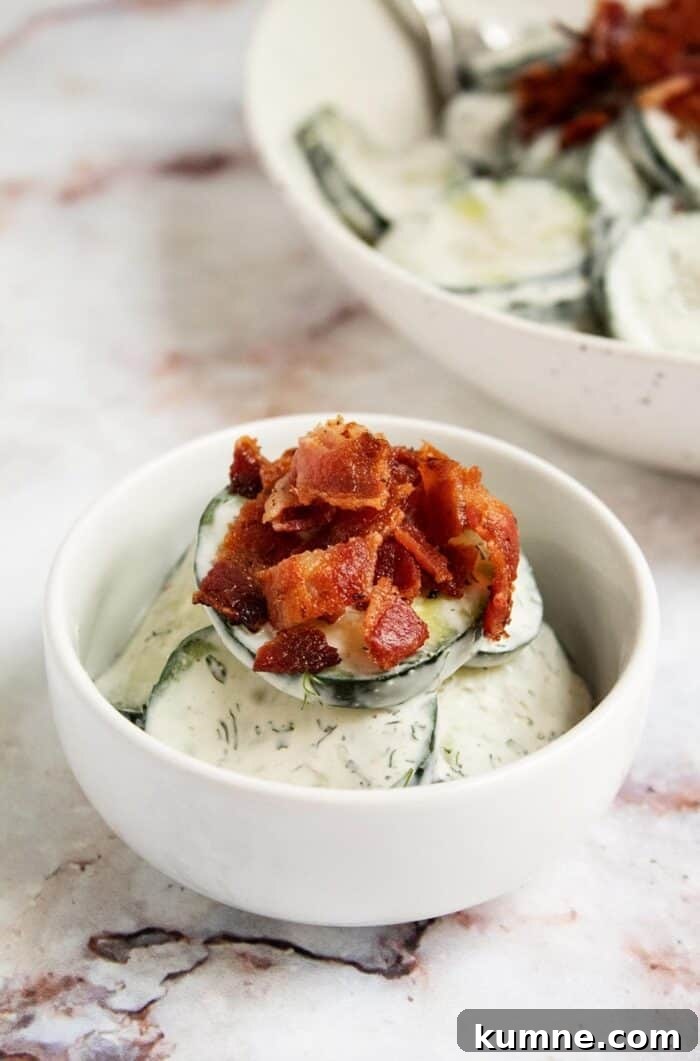 Keto Cucumber and Bacon Salad with Creamy Dill Dressing 14 closeup view of keto cucumber salad with a slice of bacon crumbled on top