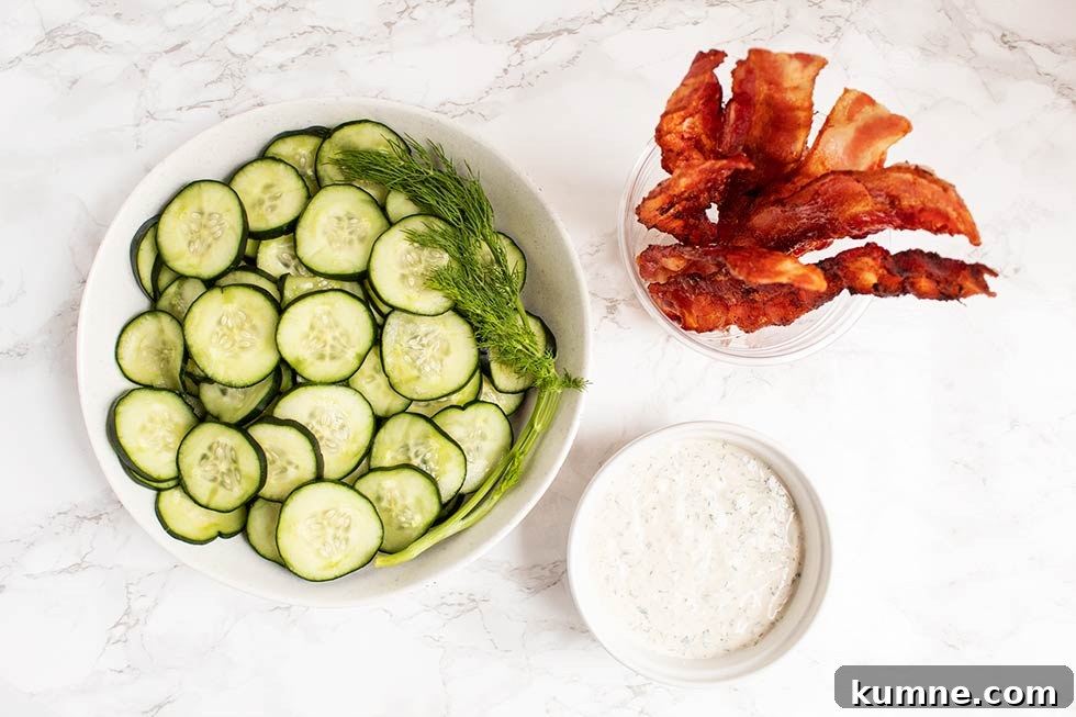 Keto Cucumber and Bacon Salad with Creamy Dill Dressing 3 overhead view of keto cucumber salad ingredients including ranch dressing, cucumbers, and bacon