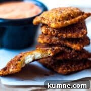 Crispy Ravioli with Roasted Red Pepper Sauce on white parchment paper.
