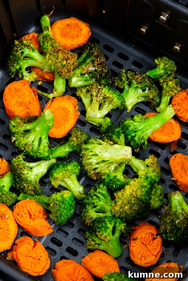 Broccoli and carrots in the basket of the air fryer.