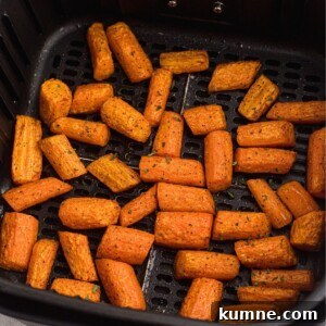 Air fried carrots in the basket after being seasoned and cooked, then garnished with parsley