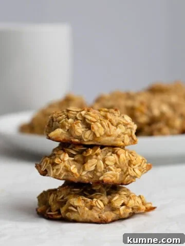 three banana breakfast cookies stacked with a plate of cookies behind