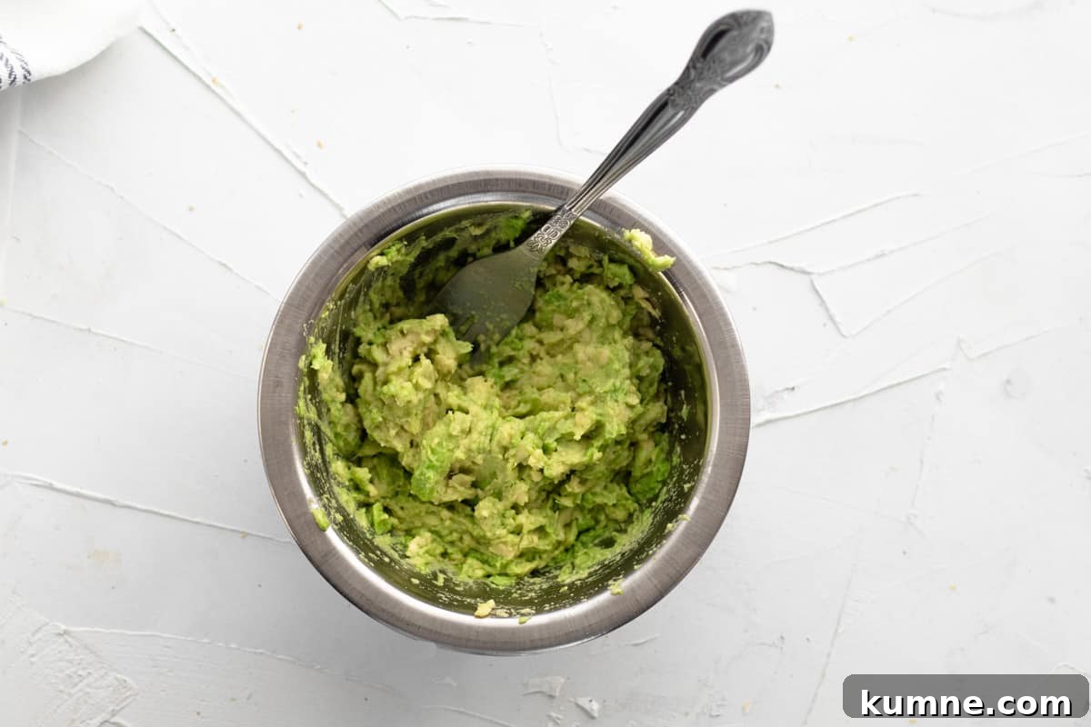 Copycat Dunkin' Avocado Toast Recipe with 3 Ingredients 6 mashed avocado in bowl with a fork