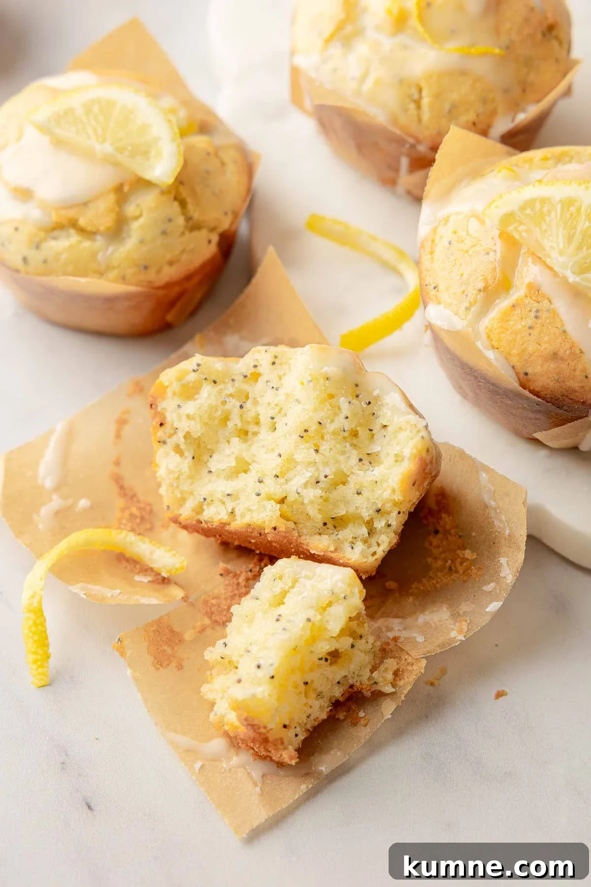 Gluten-Free Lemon Poppy Seed Muffins Recipe for Moist, Zesty Bites 3 Halved lemon poppy seed muffin showing moist crumb with glaze and zest on parchment.
